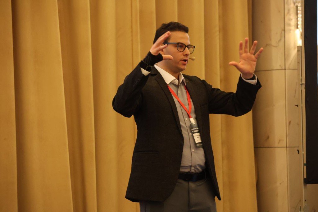 Prof. Dr. Ahmed Ebada gesturing on stage during the E/E Systems Summit 2026 keynote